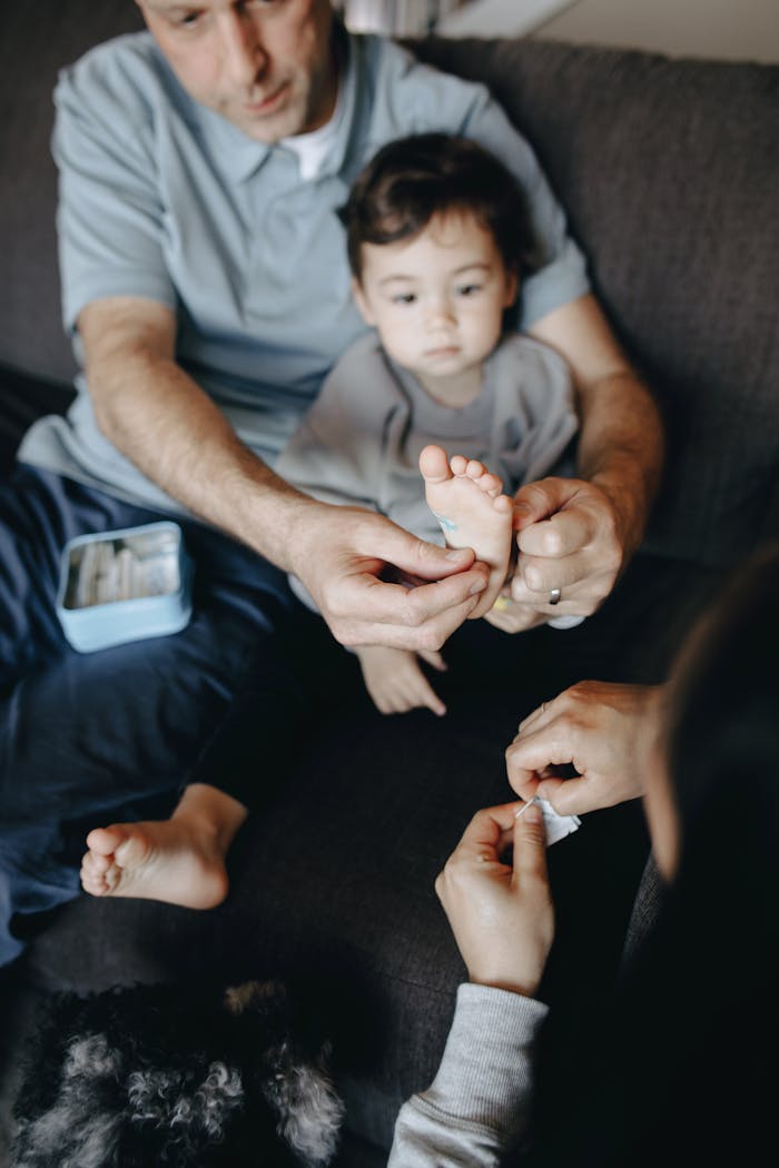 Home A family tending to a child's foot injury with first aid at home.
